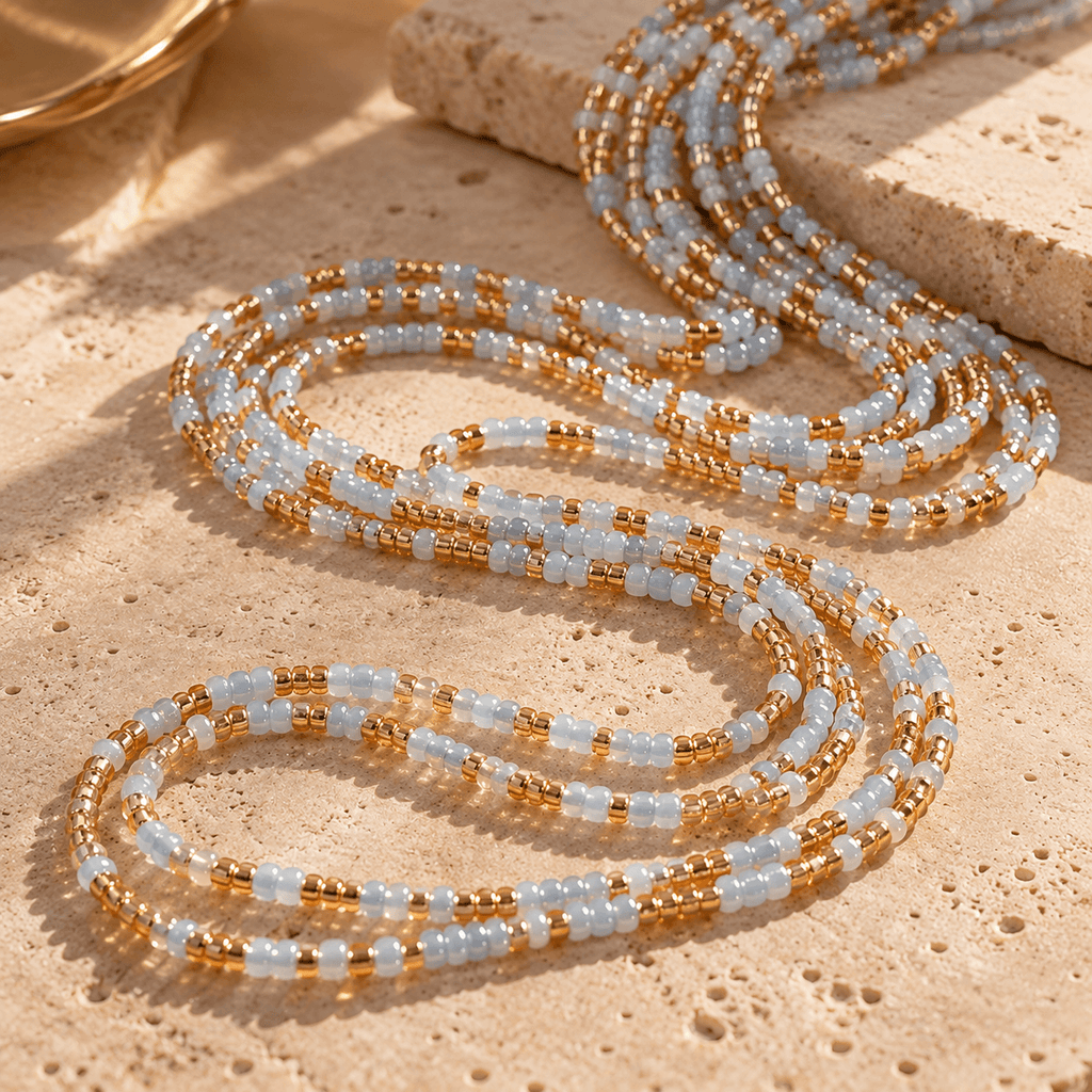 Blue and gold 2mm tie-on waist beads coiled together, showing the bead colours and pattern.
